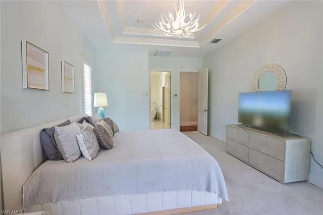 a bedroom with a large bed and a chandelier