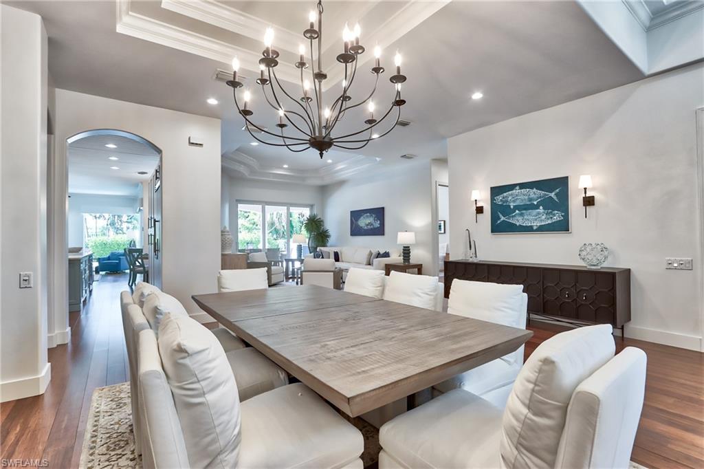 678 11th Avenue South Naples, FL 34102 - Photo 5 of 34 a view of a dining room with furniture a chandelier and wooden floor