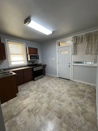 a kitchen with granite countertop a refrigerator and a stove top oven