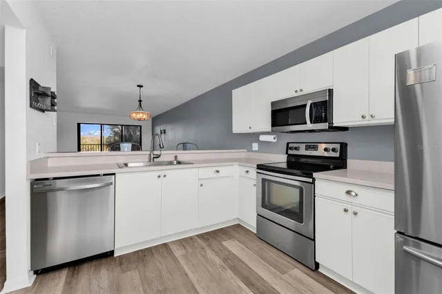 a kitchen with stainless steel appliances a stove microwave and sink