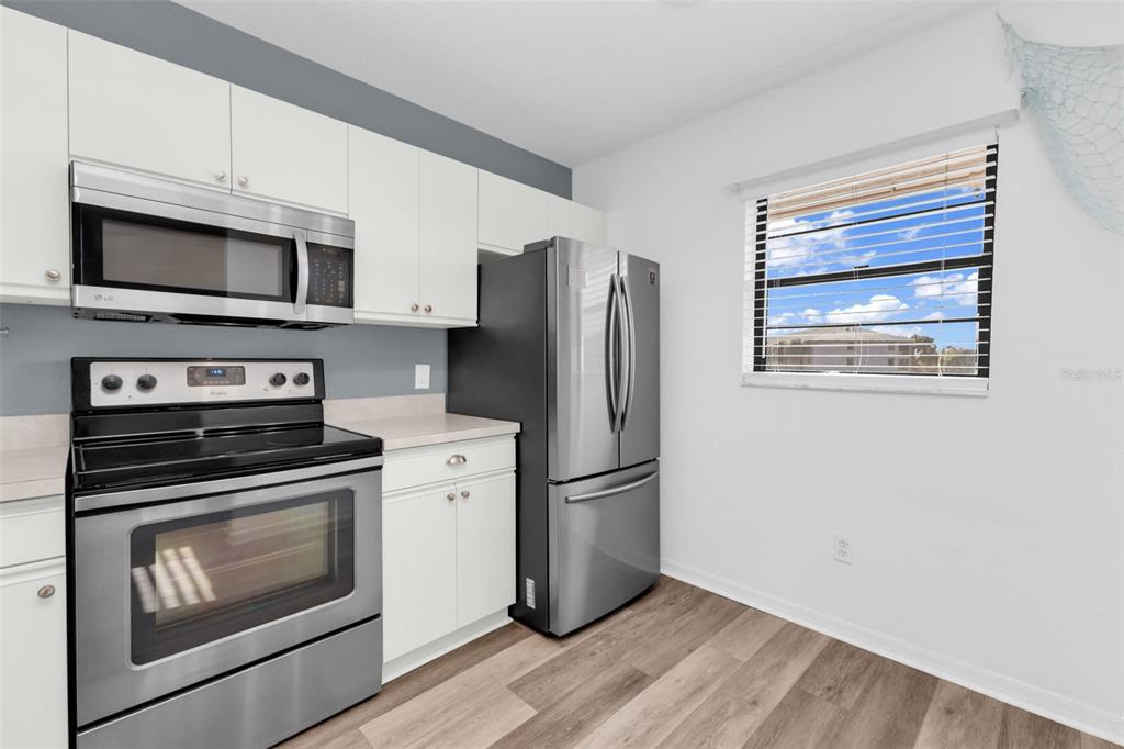 175 Kings Highway, Unit B6526 Punta Gorda, FL 33983 - Photo 6 of 44 a kitchen with stainless steel appliances a stove microwave and a refrigerator