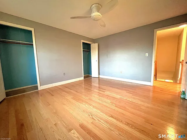 a view of an empty room with wooden floor