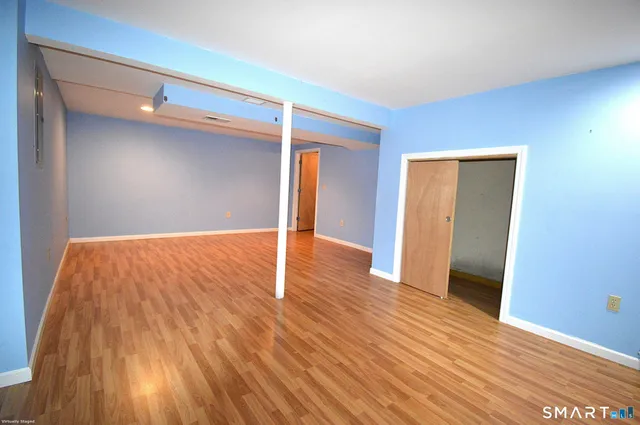 a view of empty room with wooden floor