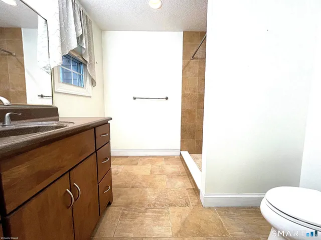 a bathroom with a sink a toilet and a mirror