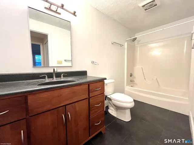 a bathroom with a sink a toilet a mirror and shower
