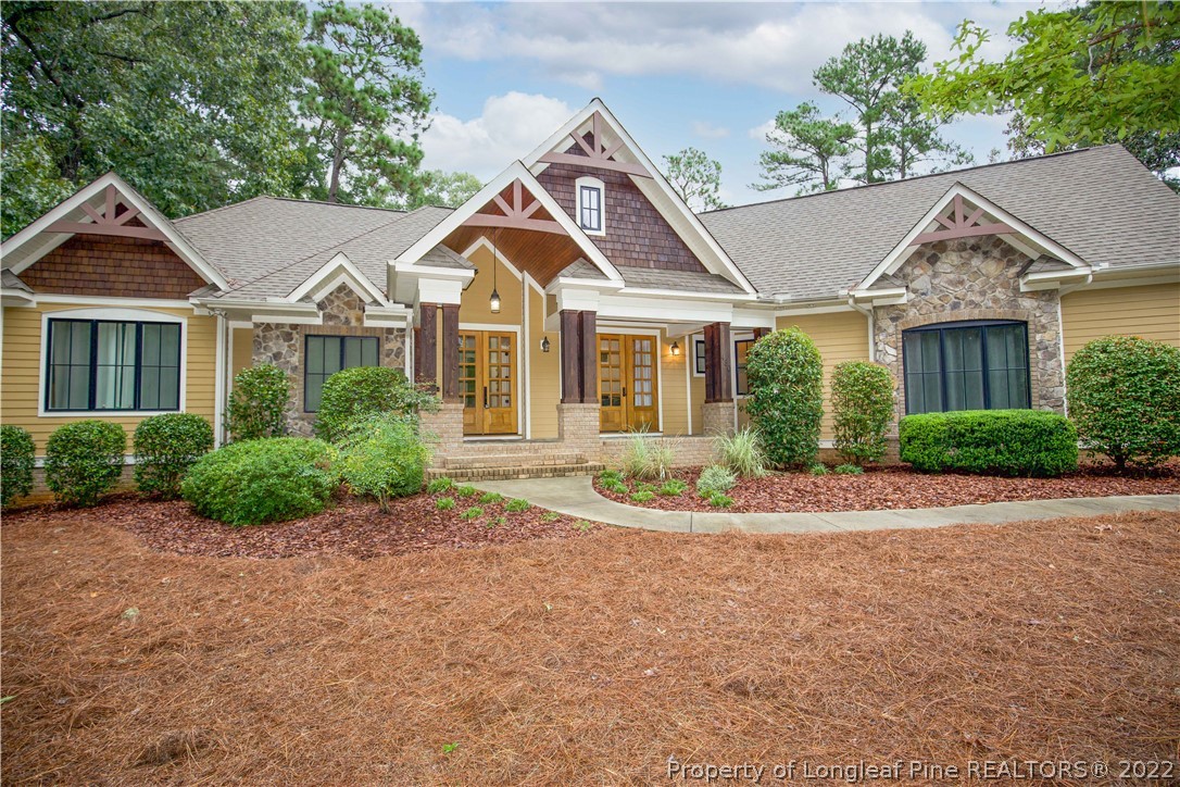480 Highland Road Southern Pines, NC 28387 - Photo 1 of 50 a front view of a house with a yard and potted plants