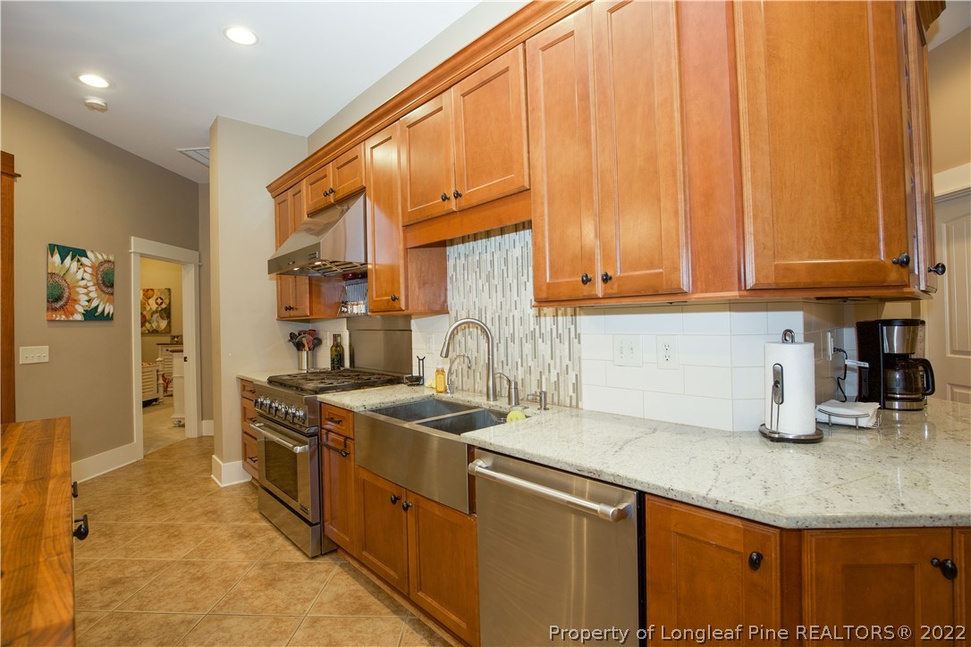 480 Highland Road Southern Pines, NC 28387 - Photo 15 of 50 a kitchen with stainless steel appliances granite countertop a sink a stove and a refrigerator