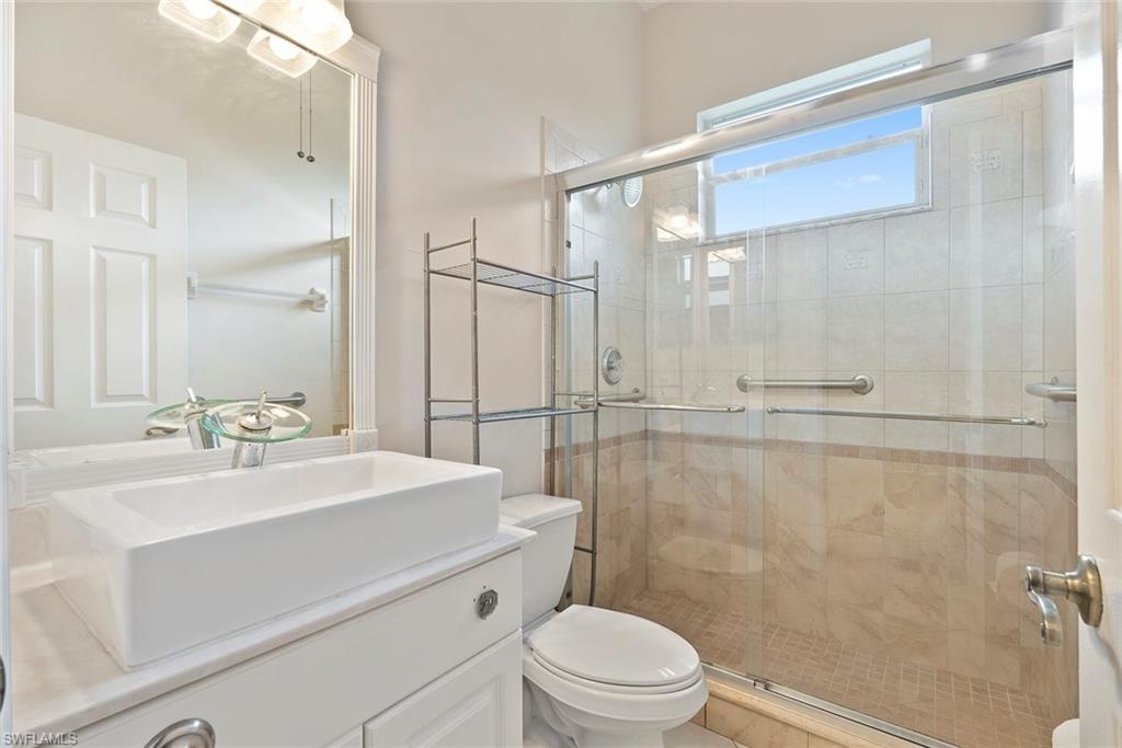 3262 Citron Drive Naples, FL 34120 - Photo 18 of 38 a bathroom with a sink a mirror a toilet and shower