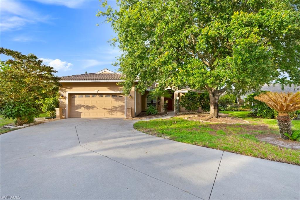 3262 Citron Drive Naples, FL 34120 - Photo 4 of 38 a front view of a house with a yard and garage