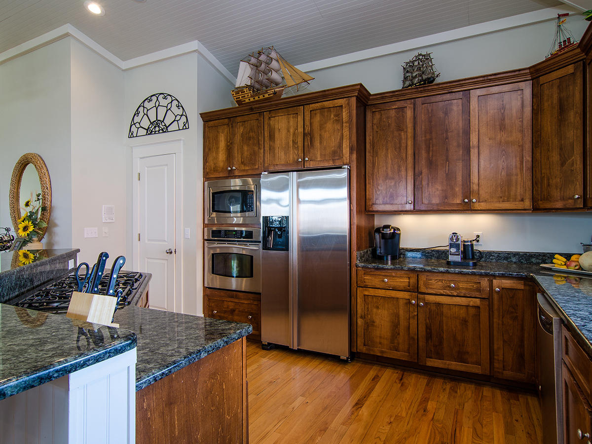 617 Blue Mountain Road Santa Rosa Beach, FL 32459 - Photo 12 of 24 a kitchen with granite countertop a refrigerator stove and cabinets