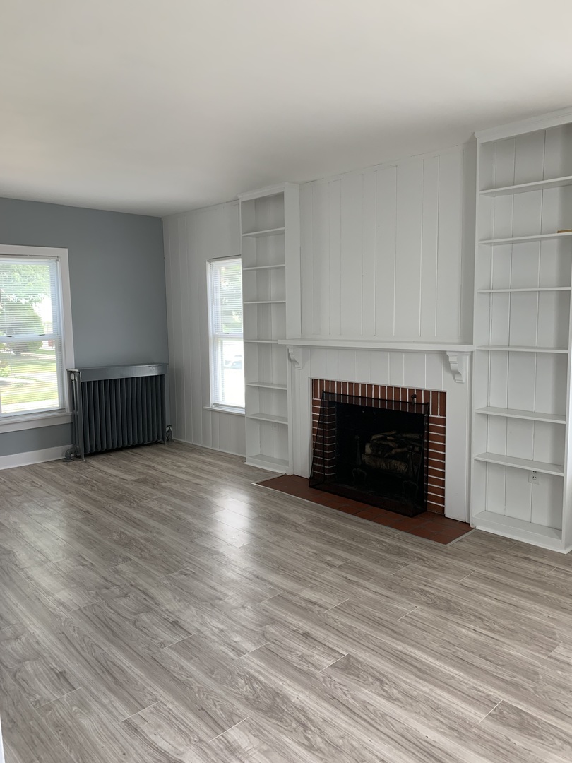 370 Ryerson Avenue Elgin, IL 60123 - Photo 4 of 21 an empty room with wooden floor fireplace and windows