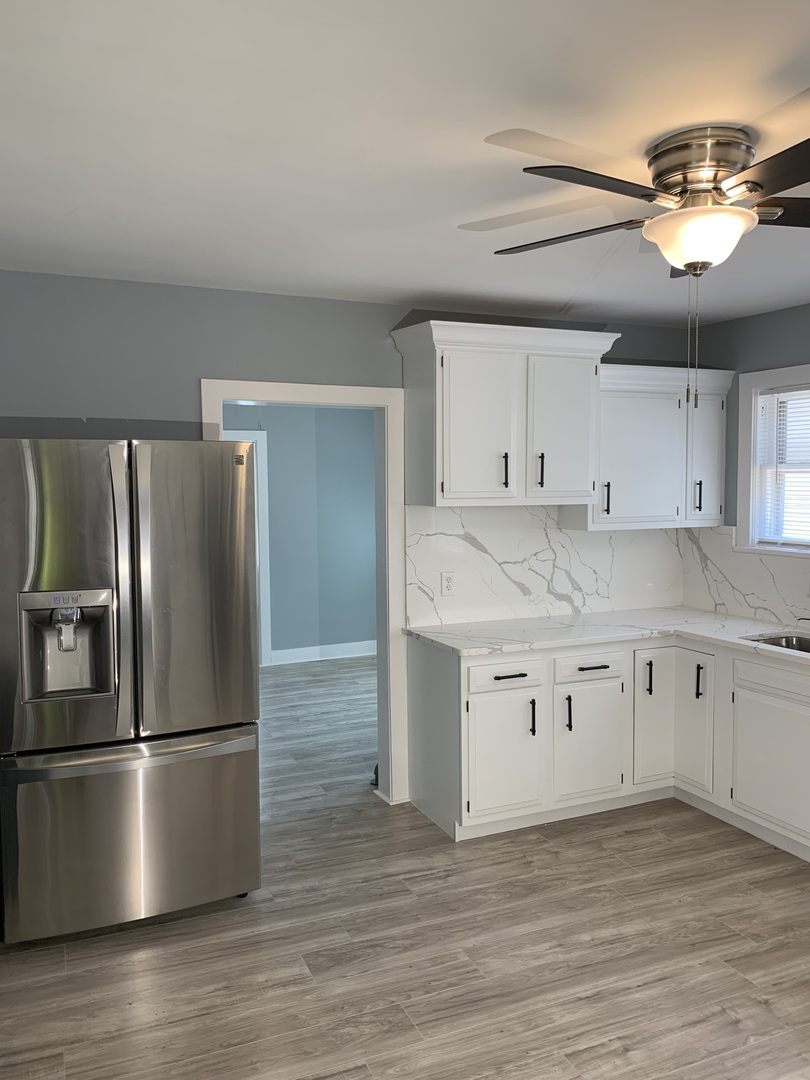 370 Ryerson Avenue Elgin, IL 60123 - Photo 6 of 21 a kitchen with stainless steel appliances granite countertop a refrigerator a sink dishwasher a stove and white countertops with wooden floor