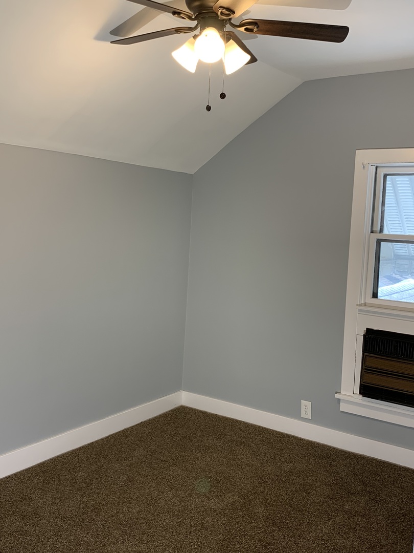 370 Ryerson Avenue Elgin, IL 60123 - Photo 10 of 21 an empty room with a chandelier fan and wooden floor