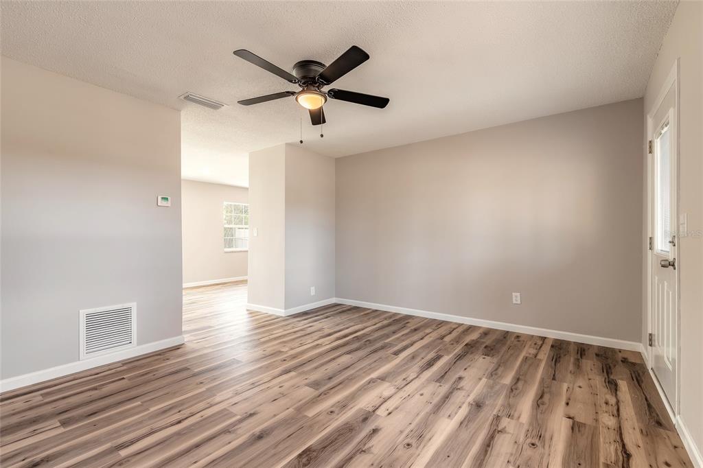 1605 Bradford Road Edgewater, FL 32132 - Photo 5 of 30 an empty room with wooden floor and a ceiling fan