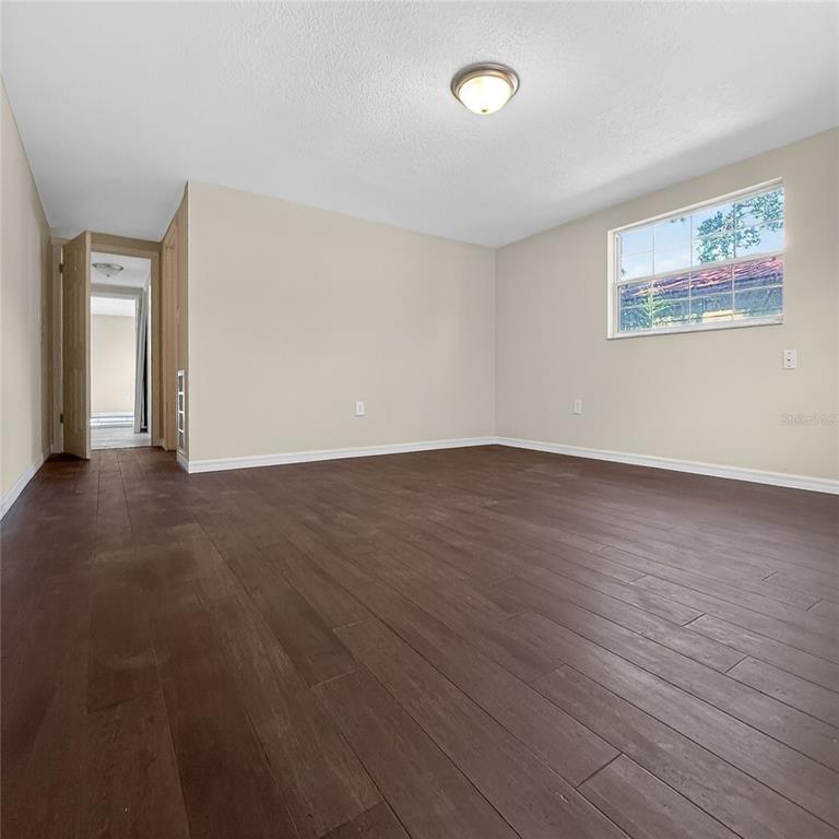 17220 Estes Road Lutz, FL 33548 - Photo 20 of 25 an empty room with wooden floor and windows