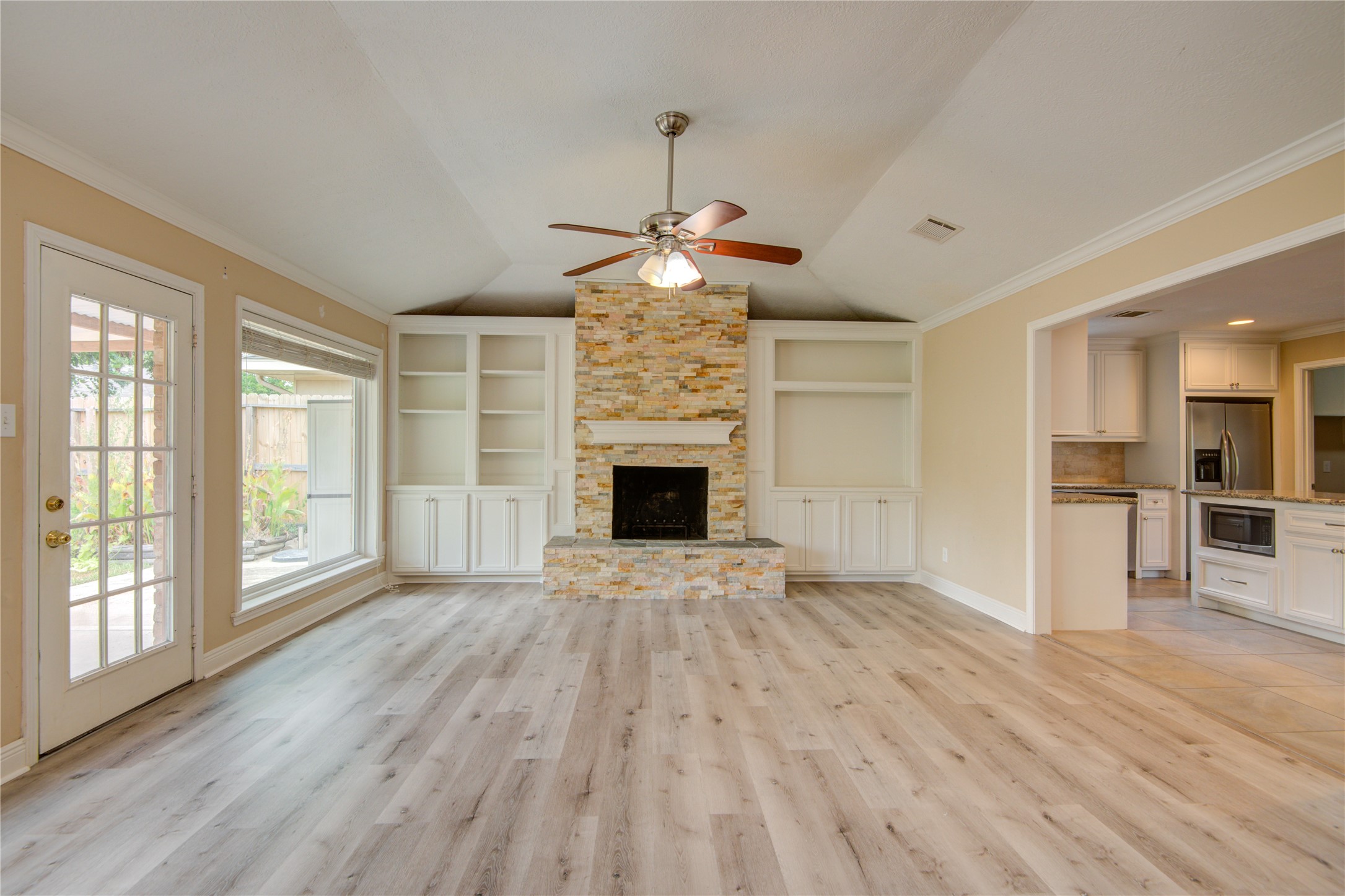 a view of a livingroom with a fireplace wooden floor and windows