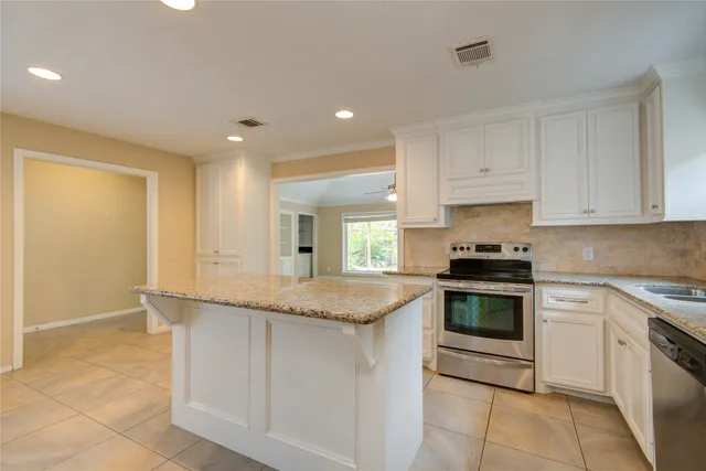a kitchen with granite countertop cabinets stainless steel appliances and a counter space
