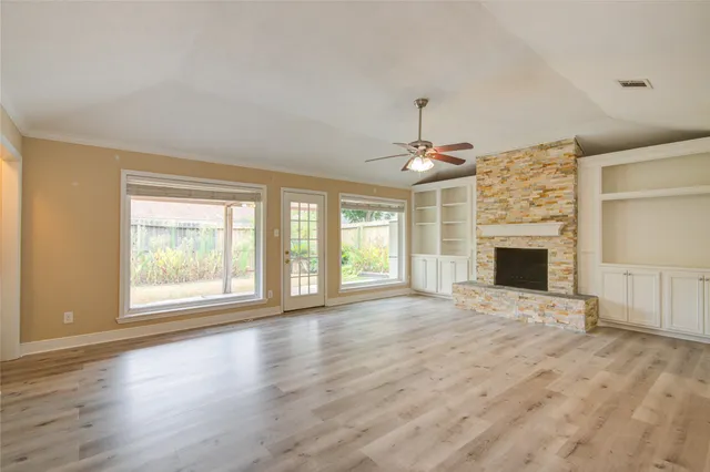 an empty room with windows fireplace and windows