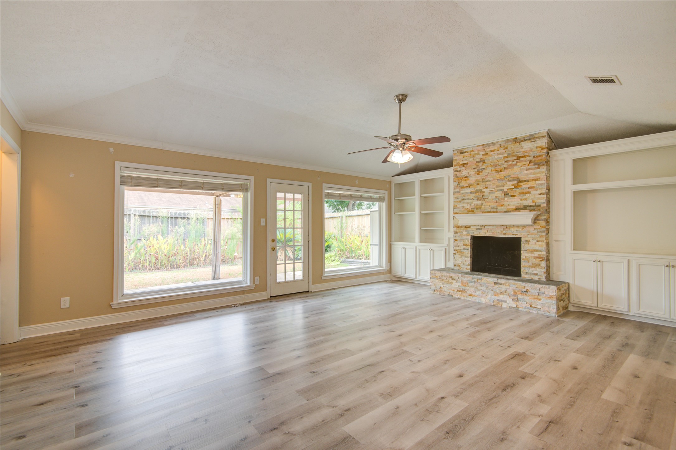 14211 Ella Lee Lane Houston, TX 77077 - Photo 16 of 42 an empty room with windows fireplace and windows