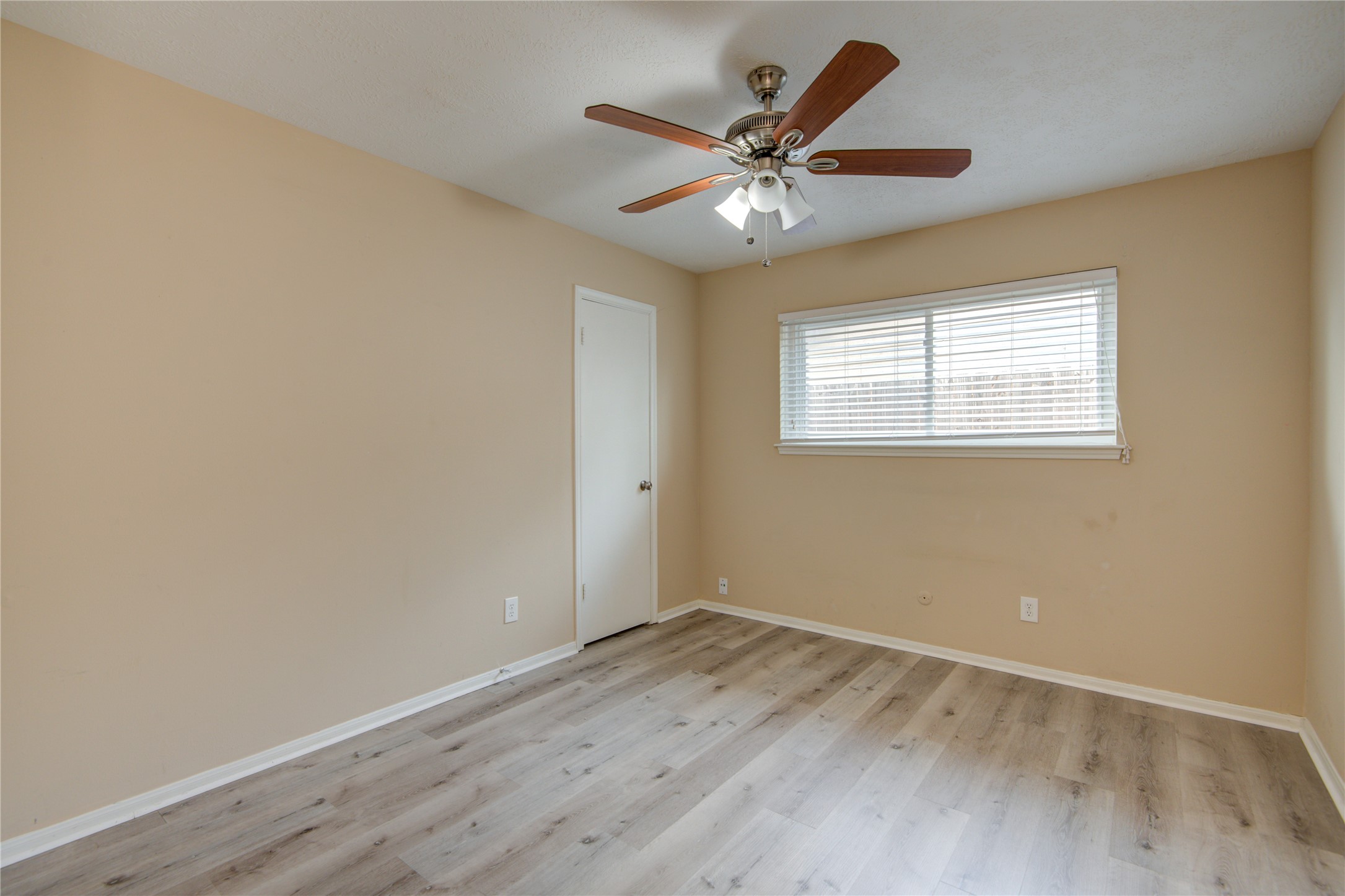 14211 Ella Lee Lane Houston, TX 77077 - Photo 22 of 42 an empty room with wooden floor fan and windows
