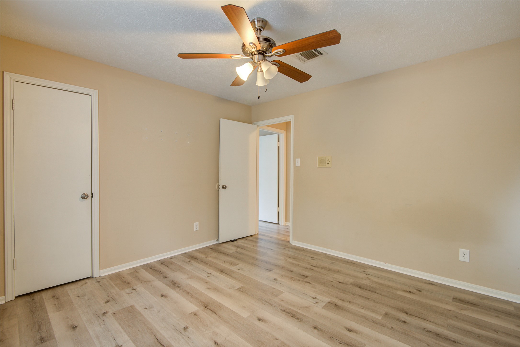 14211 Ella Lee Lane Houston, TX 77077 - Photo 25 of 42 an empty room with wooden floor and ceiling fan