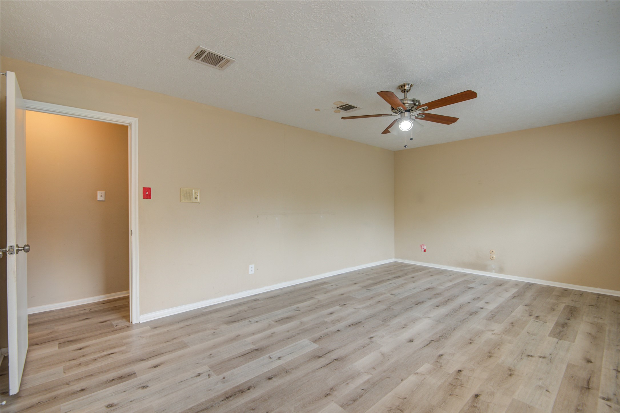 14211 Ella Lee Lane Houston, TX 77077 - Photo 27 of 42 an empty room with wooden floor and ceiling fan