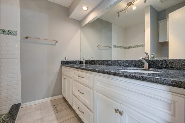 a bathroom with a granite countertop sink and a mirror