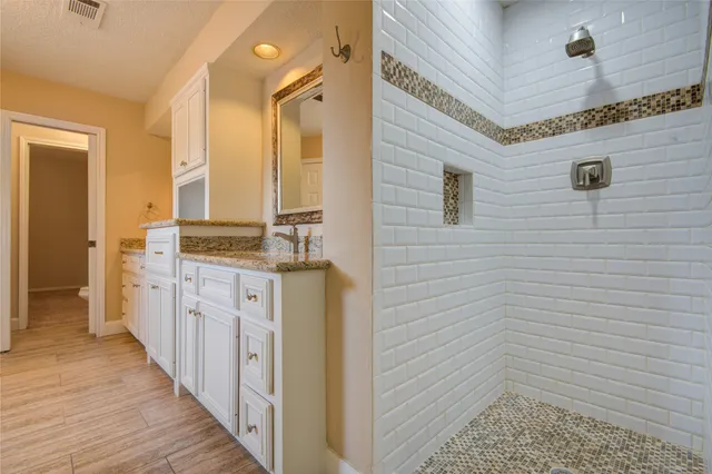 a spacious bathroom with a granite countertop sink and a mirror