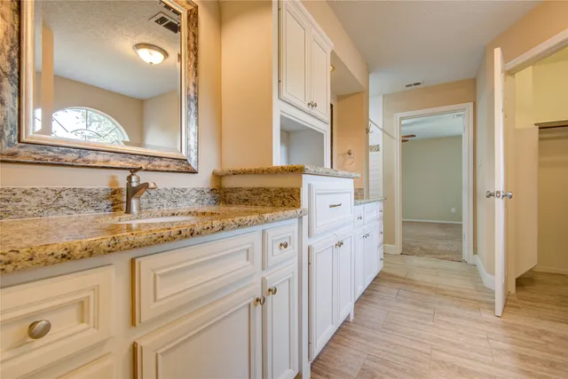a spacious bathroom with a granite countertop sink mirror and a