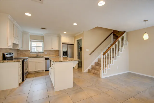 a kitchen with white cabinets and white appliances