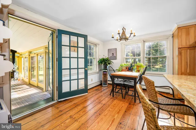 a dining room with furniture a chandelier and wooden floor
