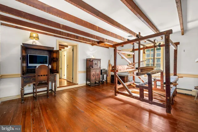 a view of a room with wooden floor table and chairs