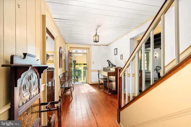 a view of a hallway with wooden floor and staircase