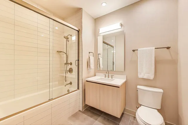 a bathroom with a bathtub shower sink mirror and toilet
