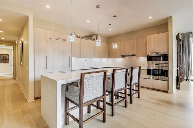 a kitchen with stainless steel appliances granite countertop a table chairs sink and cabinets