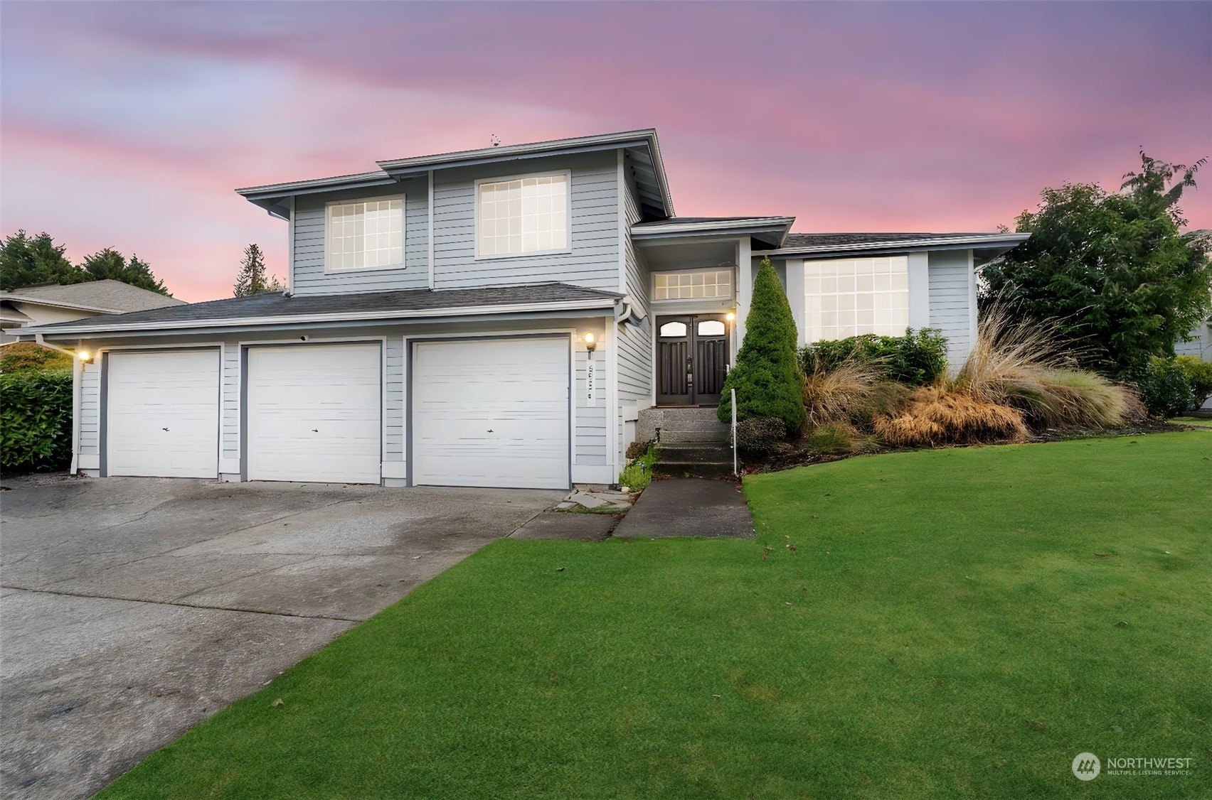 a front view of a house with a yard and garage