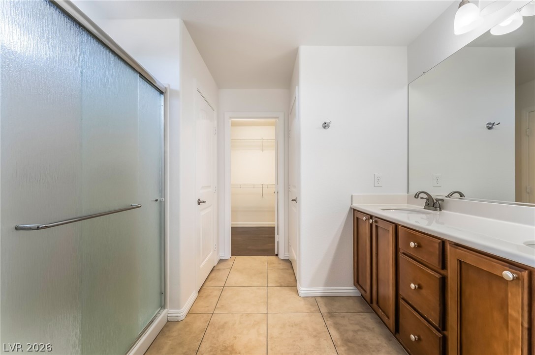 3175 Via Seranova Henderson, NV 89044 - Photo 23 of 45 This bathroom features a shower, a double vanity, and a well-appointed walk-in closet.