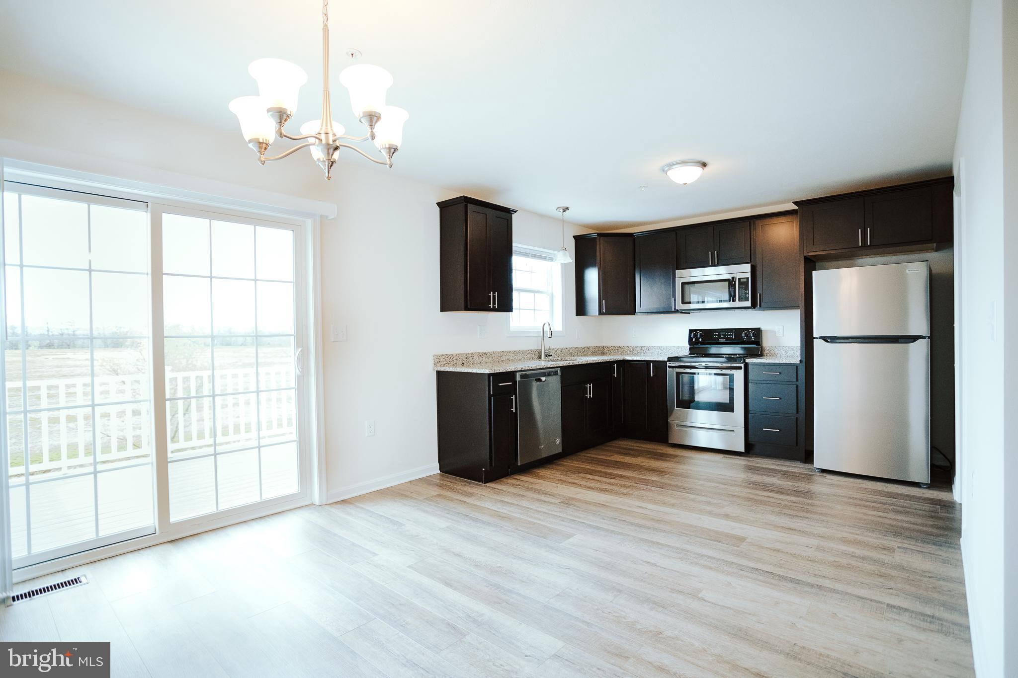 31 Deatrick Drive Gettysburg, PA 17325 - Photo 2 of 11 a kitchen with stainless steel appliances granite countertop a refrigerator a sink dishwasher a stove with wooden floor and cabinets