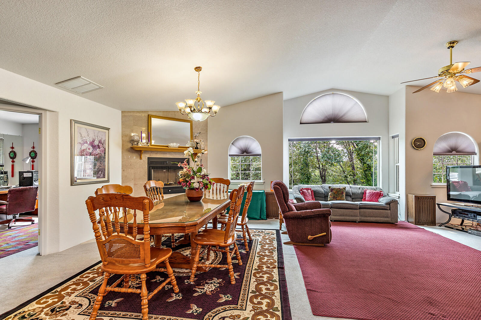 9996 Blackwell Road Central Point, OR 97502 - Photo 8 of 46 a dining room with furniture a fireplace and a chandelier