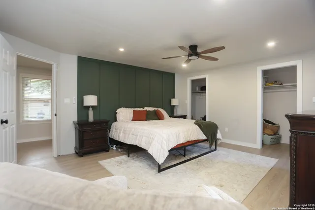 a spacious bedroom with a bed and a ceiling fan