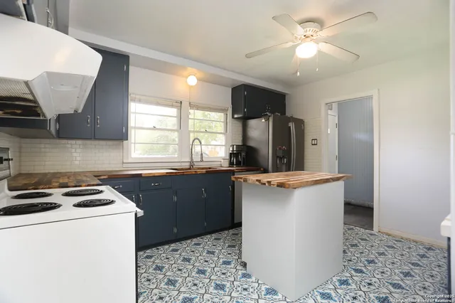 a kitchen with a refrigerator sink and wooden cabinets
