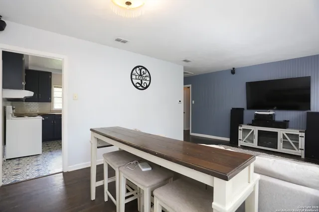 a spacious bedroom with a bed and a flat screen television