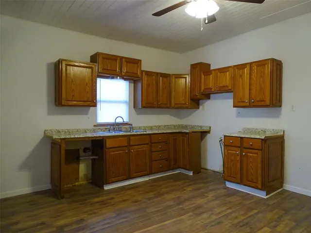 a kitchen with stainless steel appliances granite countertop a sink and dishwasher a stove top oven with wooden floor