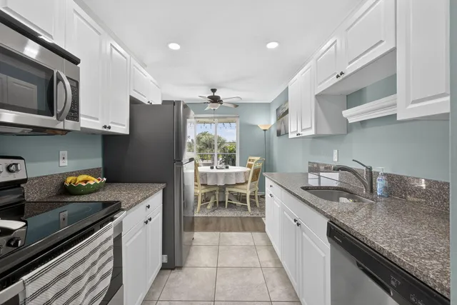 a kitchen with stainless steel appliances granite countertop a sink and a refrigerator