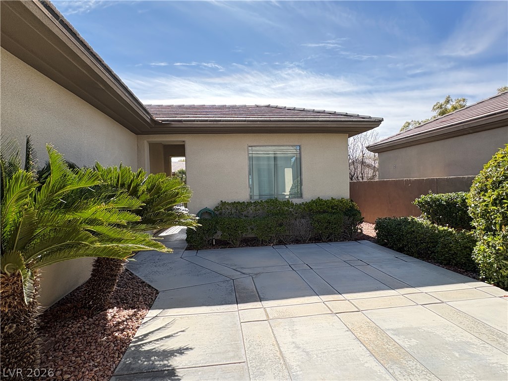10 Caprington Road Henderson, NV 89052 - Photo 29 of 44 A well-maintained outdoor space awaits, featuring lush greenery and a tiled roofline.