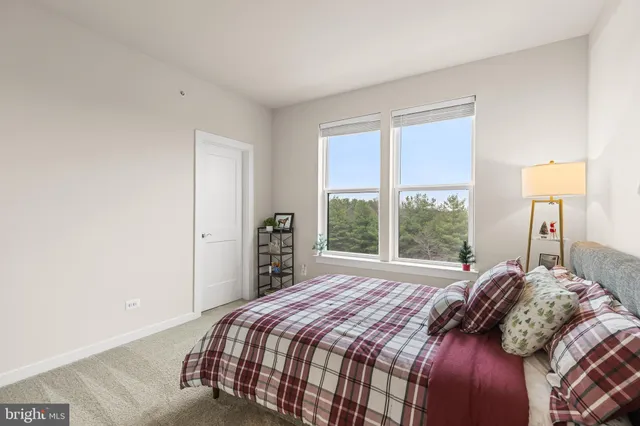 a bedroom with a bed and a large window