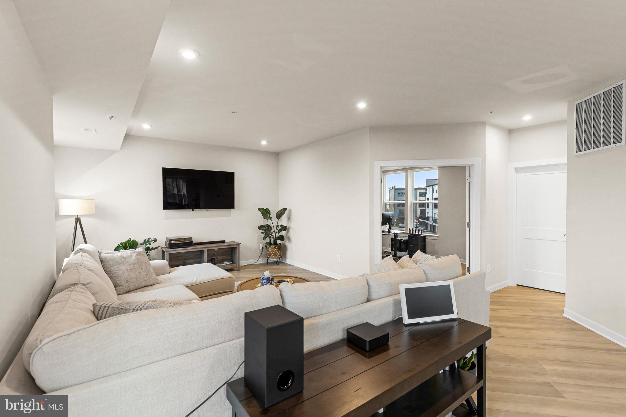 43769 Transit Square Ashburn, VA 20147 - Photo 10 of 36 a living room with furniture a flat screen tv and a wooden floor
