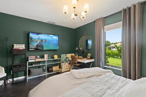 a bedroom with a bed and large mirror with window