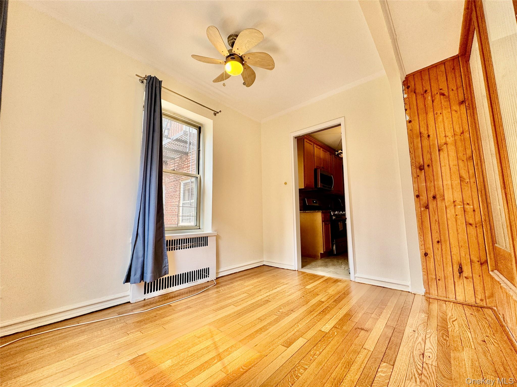 113-14 72nd Road, Unit 1M Queens, NY 11375 - Photo 11 of 20 a view of an empty room with wooden floor and a window