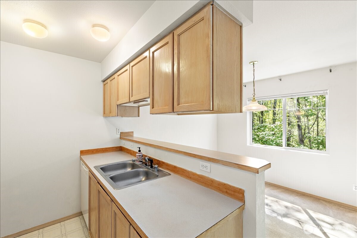 18930 Bothell Everett Highway, Unit B303 Bothell, WA 98012 - Photo 11 of 20 a kitchen with a sink a stove and a window